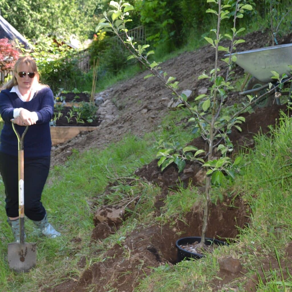 Andrea Koehle Jones planting a tree as part of children’s environmental education and climate action.